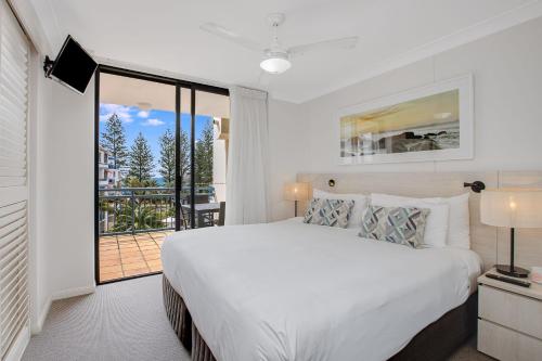 una camera bianca con letto e balcone di Calypso Plaza Resort Unit 429 a Gold Coast
