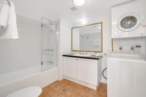 bagno bianco con lavandino e doccia di Calypso Plaza Resort Unit 429 a Gold Coast