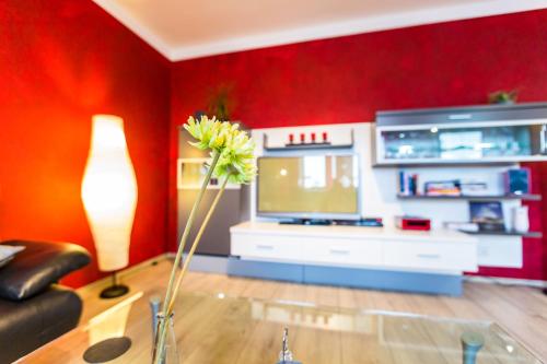 a living room with a television and a vase with a flower at Ferienwohnung Köln Messenähe in Cologne