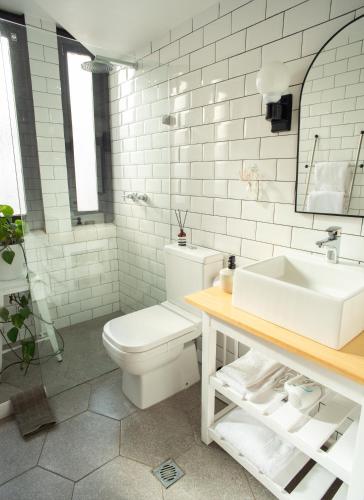 a white bathroom with a toilet and a sink at Apartamento Brown Vinyl - Alamos in Cochabamba