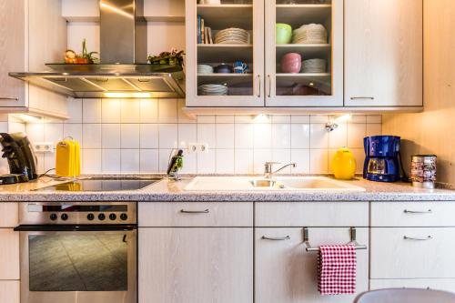 a kitchen with white cabinets and a sink at Ferienwohnung Köln Messenähe in Cologne
