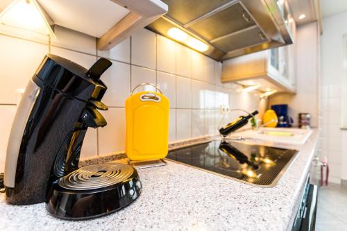 a kitchen counter top with a stove and a tea kettle at Ferienwohnung Köln Messenähe in Cologne