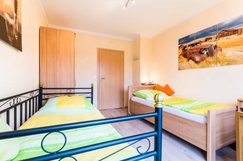 a bedroom with two beds and a painting on the wall at Ferienwohnung Köln Messenähe in Cologne