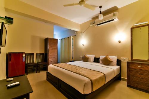 um quarto com uma cama grande num quarto em Baga Fantacia Beach Inn em Baga