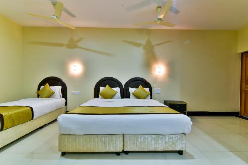 two beds in a room with two planes on the wall at Baga Fantacia Beach Inn in Baga