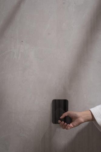 a person holding a black object on a wall at Taller de Juan - Casa Hotel in San Cristóbal de Las Casas