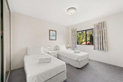 a white room with two beds and a window at Radburn Ondine Close 3 17 in Nelson Bay