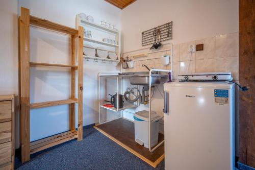 a small kitchen with a refrigerator in a room at Penzion Koucký in Bedřichov