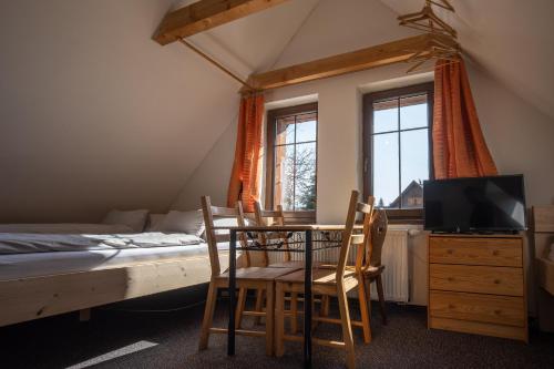 a bedroom with a bed and a table and chairs at Penzion Koucký in Bedřichov