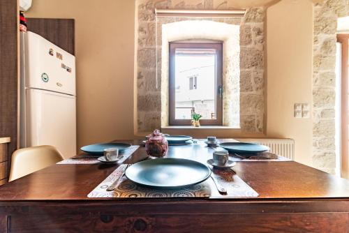 uma mesa de madeira com placas azuis na cozinha em Villa Thalasena em episkopi-heraklion