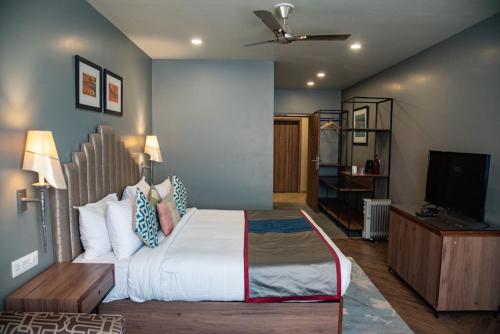 a bedroom with a bed and a flat screen tv at juSTa Mukteshwar Retreat & Spa in Mukteswar