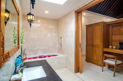 a bathroom with a sink and a bath tub at Danakha Villa Ubud in Tegalalang