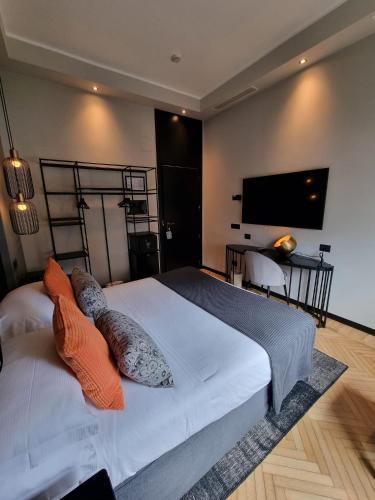a bedroom with a large bed with pillows and a flat screen tv at Grand Hotel Passetto in Ancona