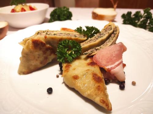 a white plate with food on a table at Gasthaus Linde in Ingelfingen