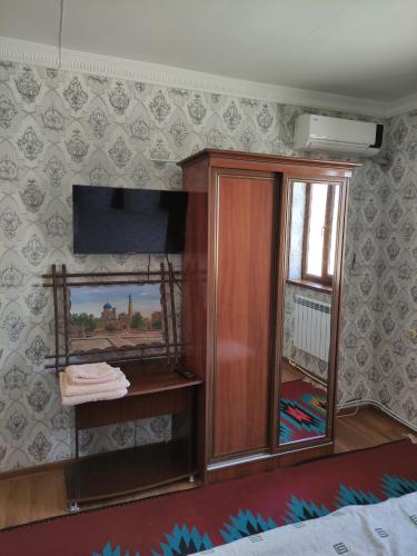 a room with a wooden cabinet and a mirror at Khiva Otabek Hotel in Khiva