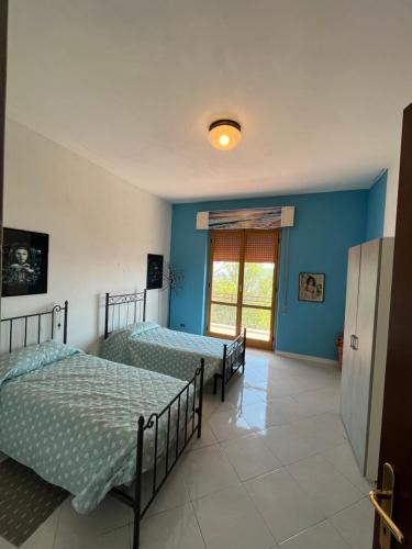 Duas camas num quarto com paredes azuis em Casa Vittoria em Bolano