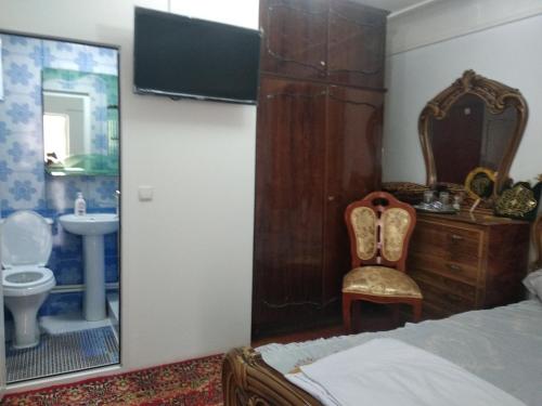 布哈拉的住宿－Al-Bashir，一间卧室配有椅子、水槽和镜子