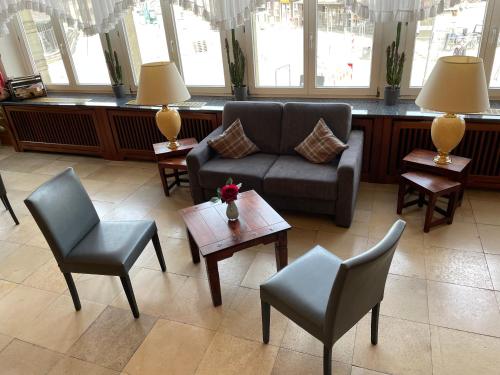 a living room with a couch and chairs and tables at Hotel Niedersächsischer Hof in Goslar