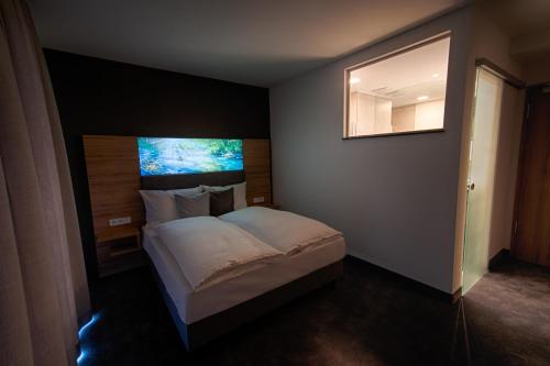 a bedroom with a bed and a mirror on the wall at Hotel Kupferzell in Kupferzell