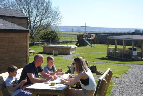 a group of people sitting at a picnic table at Delny Glamping and Farm Animals in Invergordon