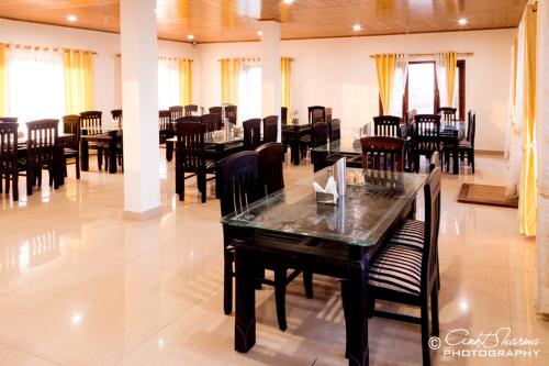 a dining room with tables and chairs in a building at Shri Shail Inn Mukteshwar in Mukteshwar