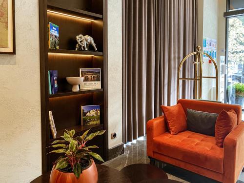 a living room with an orange chair and a table at Golden Horn Apart Hotel in Baku