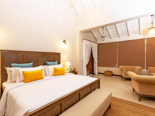 a bedroom with a large bed with yellow pillows at Heritage Boutique by Seven Angels in Kandy