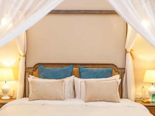 a bedroom with a large bed with blue pillows at Heritage Boutique by Seven Angels in Kandy