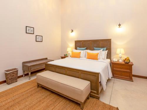 a bedroom with a large bed with yellow and blue pillows at Heritage Boutique by Seven Angels in Kandy