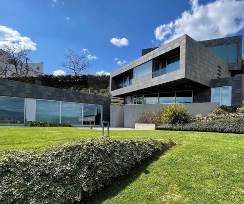a modern house with a lawn in front of it at Tres Prismas Exclusive in Sarria