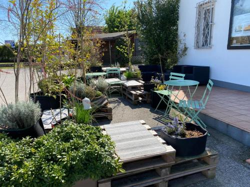 a garden with chairs and tables and potted plants at Balabuska Rooms in Codevigo