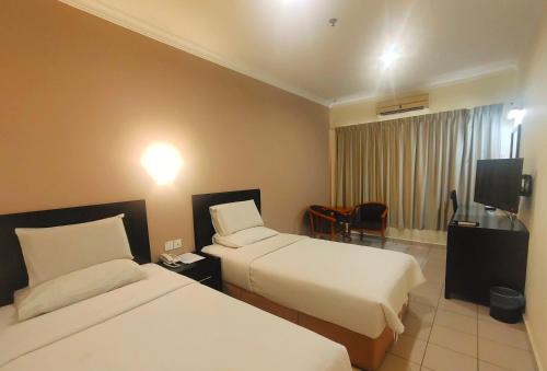 Postel nebo postele na pokoji v ubytování Megah D'aru Hotel