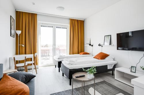 a hotel room with two beds and a tv at Hiisi Homes Nokia Nansonkatu in Nokia