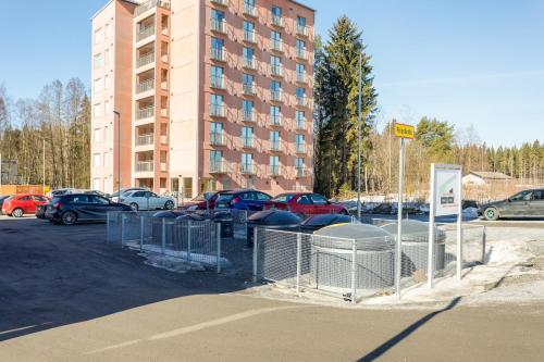 a parking lot with cars parked in front of a building at Hiisi Homes Nokia Nansonkatu in Nokia