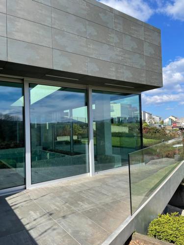 a building with glass windows on the side of it at Tres Prismas Exclusive in Sarria