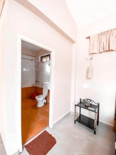 a white bathroom with a toilet and a table at NomadGao Vila Nova - Comfort, Great Views, Fast WiFi & Interesting People in Anjuna