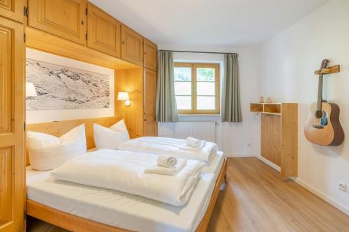 um quarto com duas camas e uma guitarra em Alpenkönig em Bolsterlang