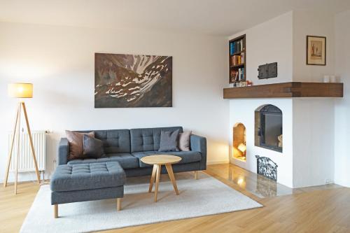 a living room with a blue couch and a table at Alpenkönig in Bolsterlang