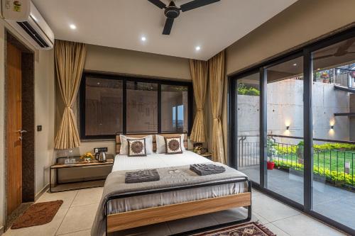1 dormitorio con cama y ventana grande en SaffronStays Cinco Elementos, Panchgani - stunning valley view pool villa en Pānchgani