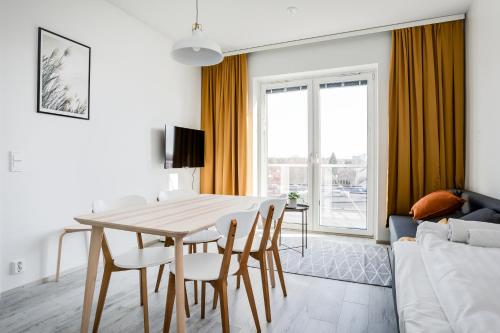 a living room with a table and chairs and a couch at Hiisi Homes Nokia Nansonkatu in Nokia