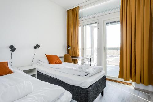 a hotel room with two beds and a window at Hiisi Homes Nokia Nansonkatu in Nokia