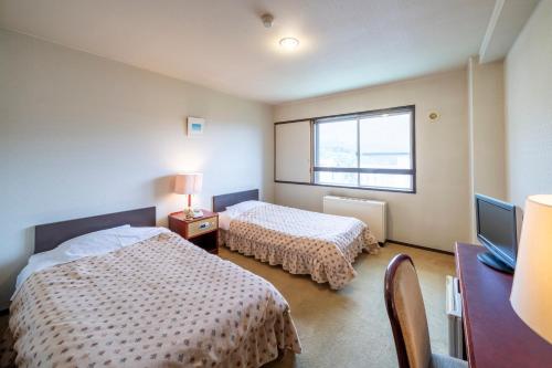 ein Schlafzimmer mit zwei Betten und einem Fenster in der Unterkunft Hotel Tagawa in Yamanouchi