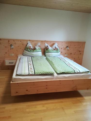 two twin beds in a bedroom with a wooden headboard at Ferienwohnung Familie Fiechtl in Fügenberg