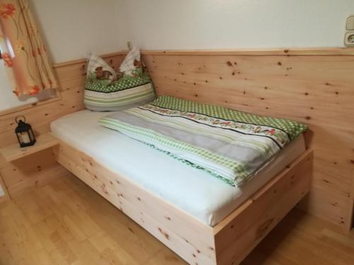 a bed in a room with a wooden frame at Ferienwohnung Familie Fiechtl in Fügenberg