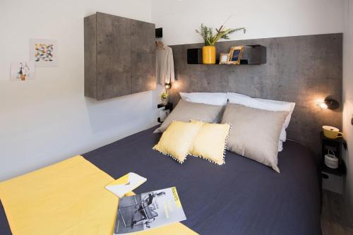 a bedroom with a large bed with yellow pillows at Camping maeva Club Les Préveils in La Tranche-sur-Mer