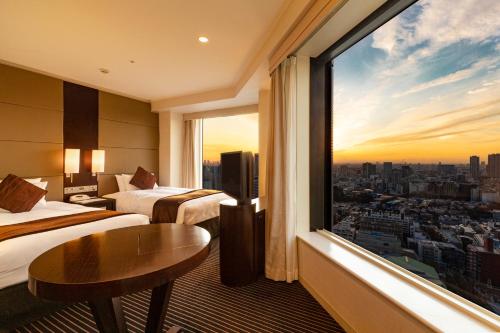 東京にある品川プリンスホテルのベッド2台と大きな窓が備わるホテルルームです。