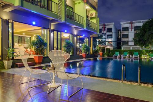 two chairs and a swimming pool in a building at Stay Resort Pattaya in North Pattaya