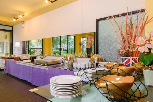 a kitchen with a table with plates and chairs at Stay Resort Pattaya in North Pattaya