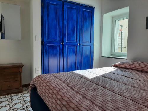 um armário azul num quarto com uma cama em Casa Sophia em Ischia