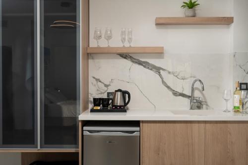 a kitchen with a sink and a counter with glasses at Archin Boutique suites in Chania